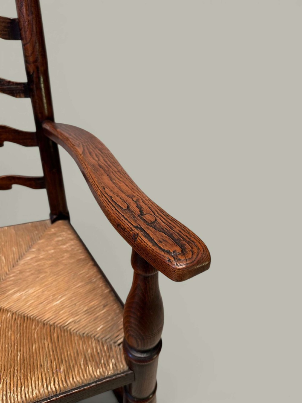A set of eight antique ash dining chairs featuring wavy ladder backs, turned stretchers, and woven rush seats, comprising six side chairs and two carver armchairs. View IX