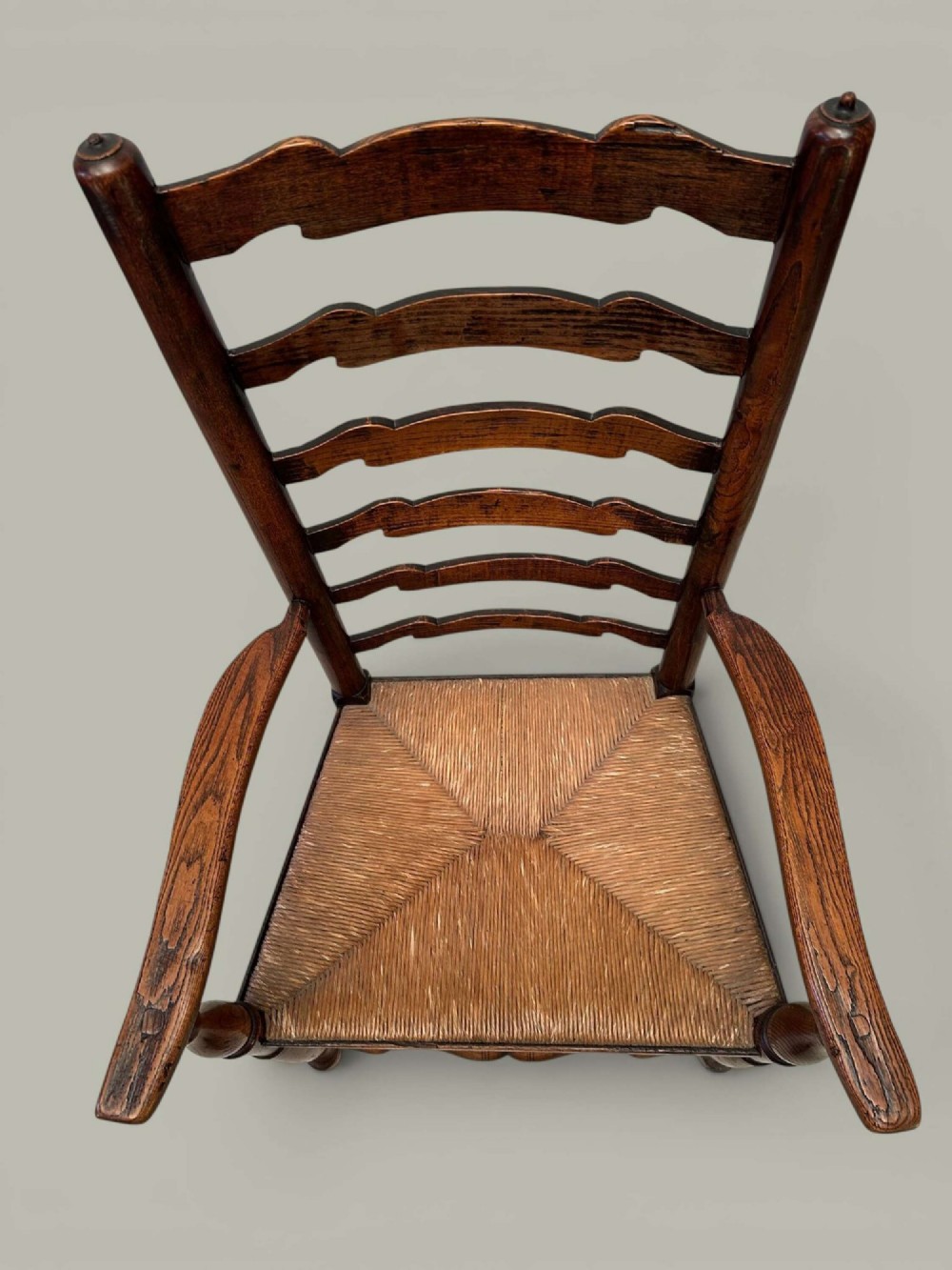 A set of eight antique ash dining chairs featuring wavy ladder backs, turned stretchers, and woven rush seats, comprising six side chairs and two carver armchairs. View XI