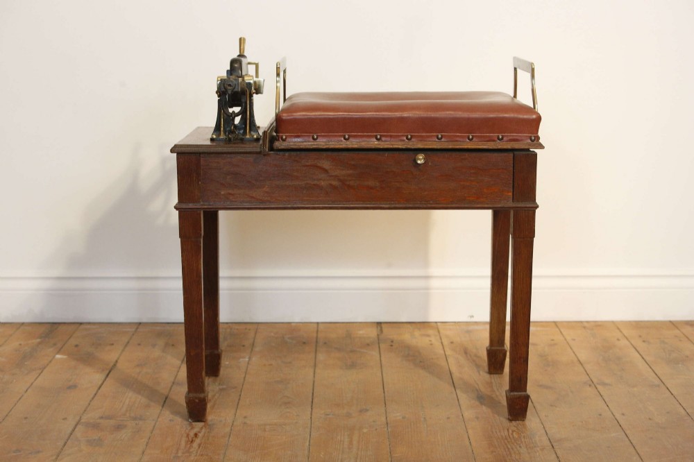 An Edwardian oak jockey scale featuring a padded brown leather seat with brass studs, brass side handles, and an integrated metal balance beam weighing mechanism. View II