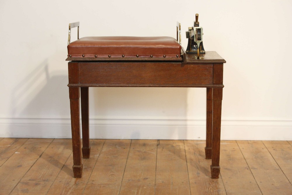 An Edwardian oak jockey scale featuring a padded brown leather seat with brass studs, brass side handles, and an integrated metal balance beam weighing mechanism. View III