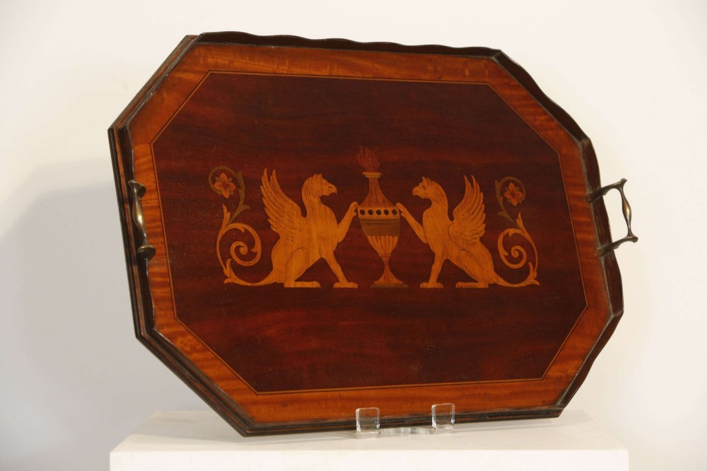 An octagonal mahogany serving tray featuring central marquetry inlay depicting twin winged griffins flanking a classical urn, with brass handles on two sides. View II