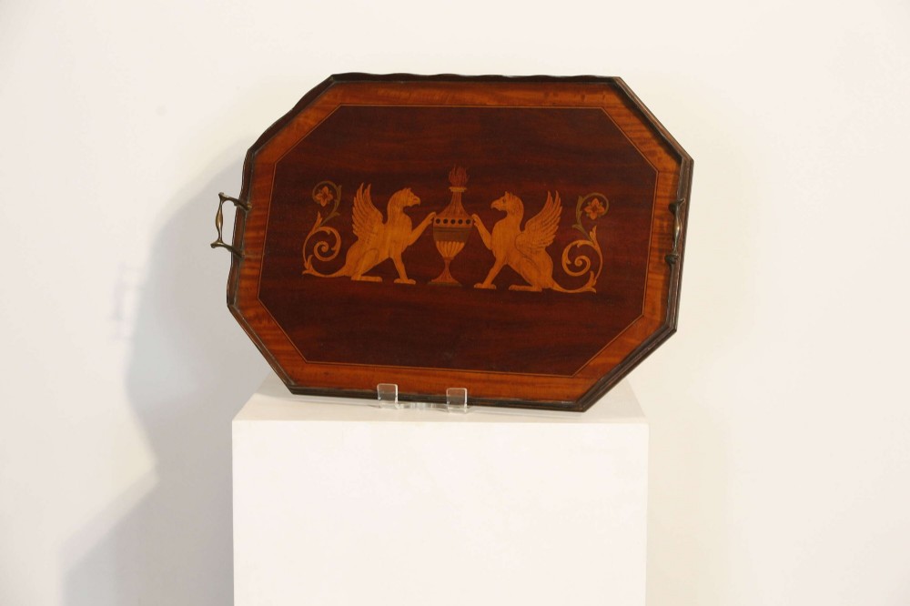 An octagonal mahogany serving tray featuring central marquetry inlay depicting twin winged griffins flanking a classical urn, with brass handles on two sides. View IV