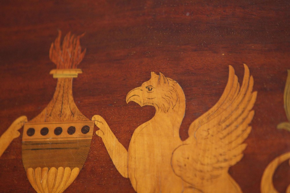 An octagonal mahogany serving tray featuring central marquetry inlay depicting twin winged griffins flanking a classical urn, with brass handles on two sides. View VI