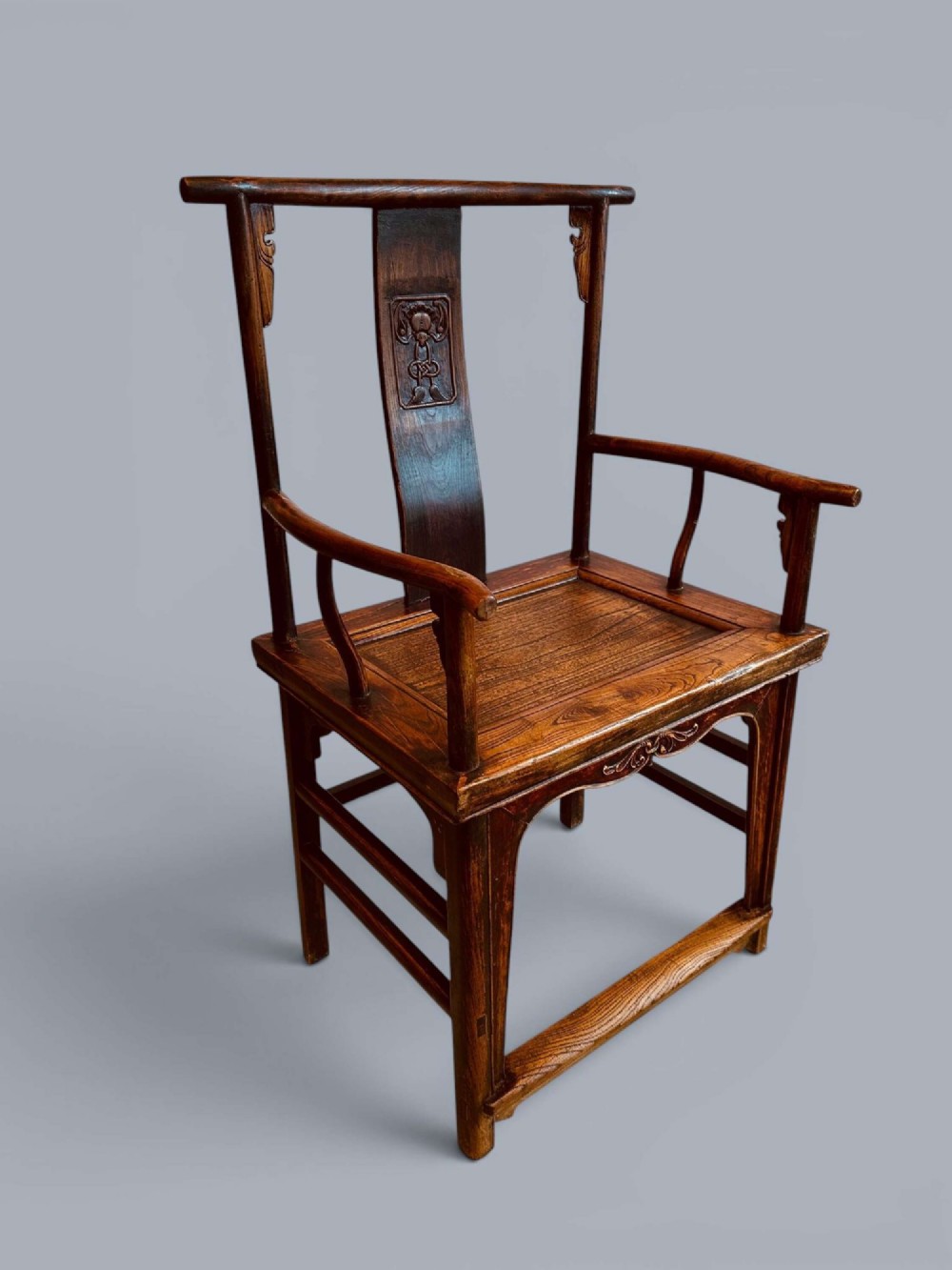 A pair of late nineteenth-century Chinese dark elm armchairs featuring carved central back splats and curved crest rails. View II