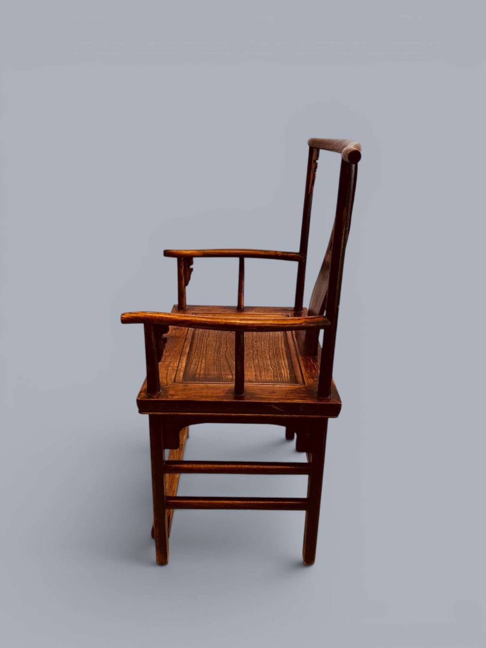 A pair of late nineteenth-century Chinese dark elm armchairs featuring carved central back splats and curved crest rails. View V
