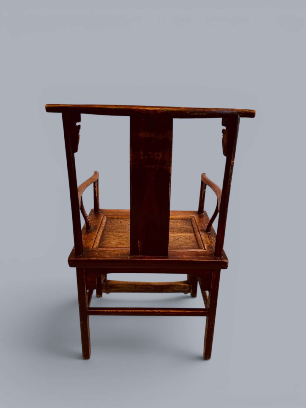 A pair of late nineteenth-century Chinese dark elm armchairs featuring carved central back splats and curved crest rails. View X