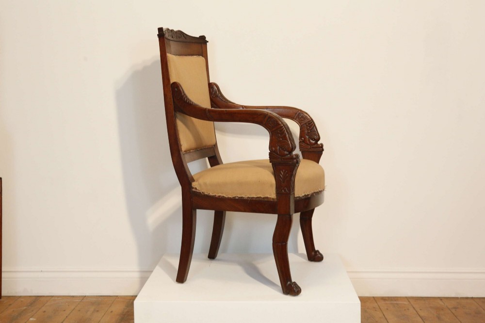An early nineteenth-century French Empire carved mahogany armchair with padded seat and backrest, curved arms, and carved front legs. View IV