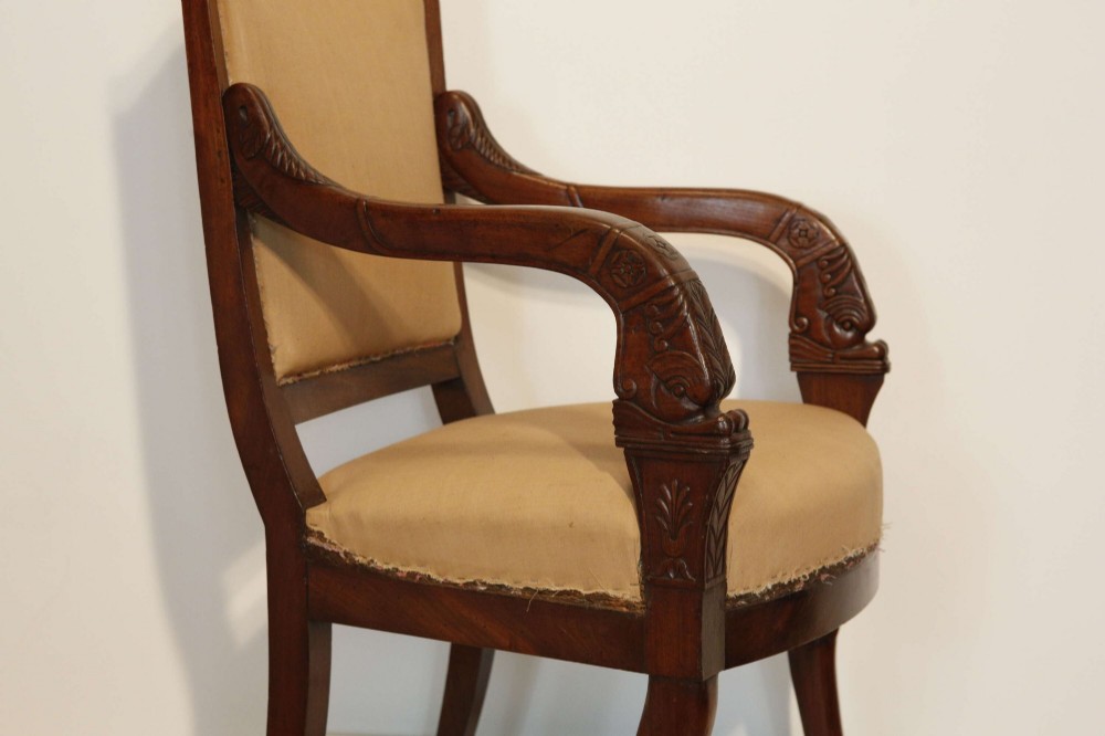 An early nineteenth-century French Empire carved mahogany armchair with padded seat and backrest, curved arms, and carved front legs. View V