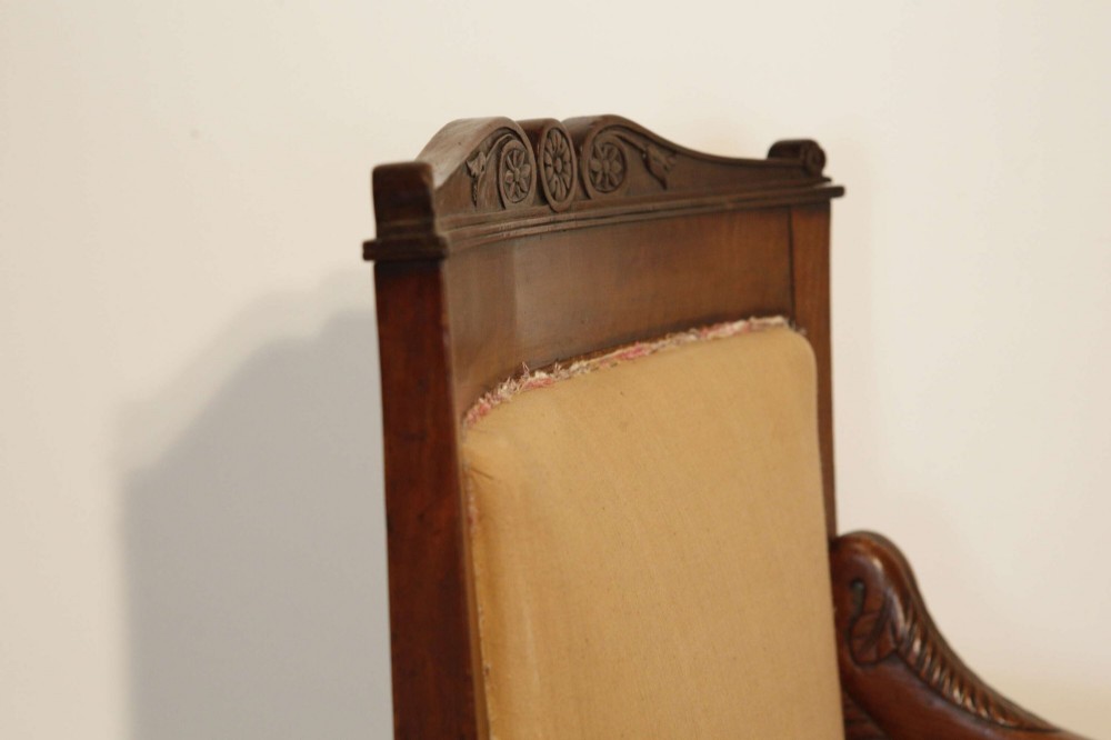 An early nineteenth-century French Empire carved mahogany armchair with padded seat and backrest, curved arms, and carved front legs. View VI