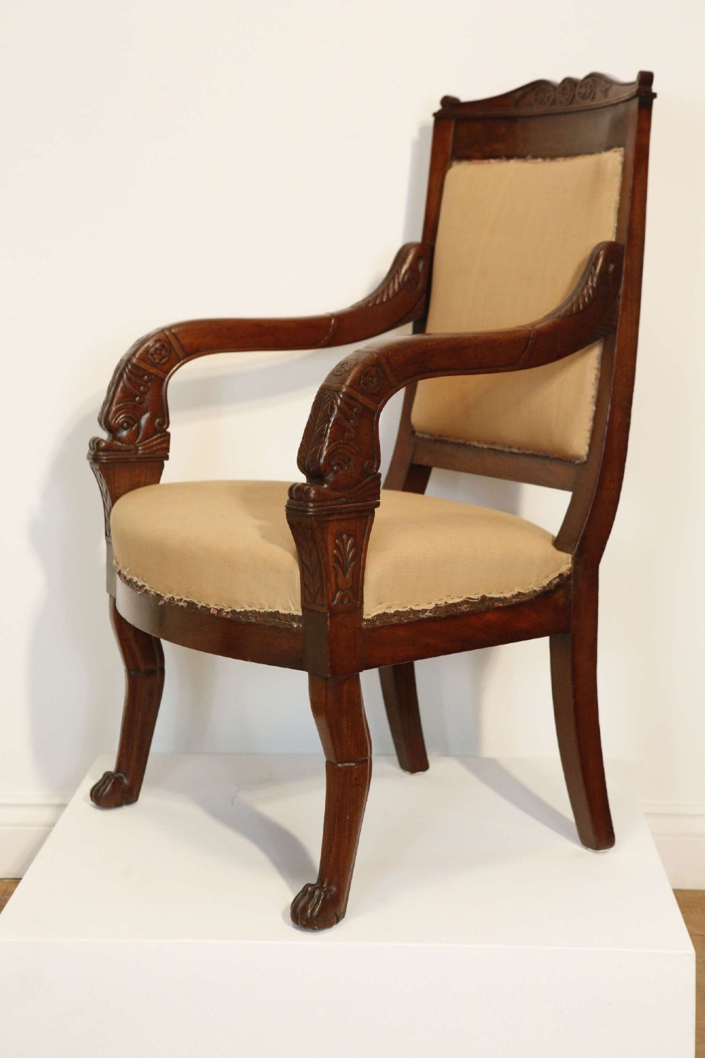 An early nineteenth-century French Empire carved mahogany armchair with padded seat and backrest, curved arms, and carved front legs. View X