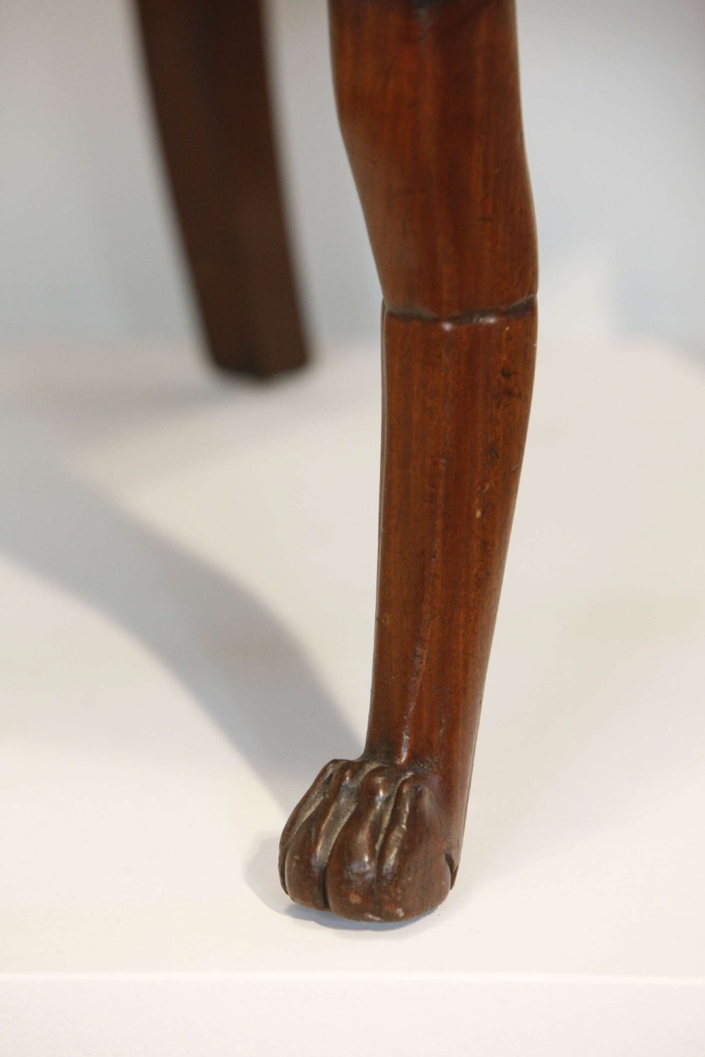 An early nineteenth-century French Empire carved mahogany armchair with padded seat and backrest, curved arms, and carved front legs. View XI