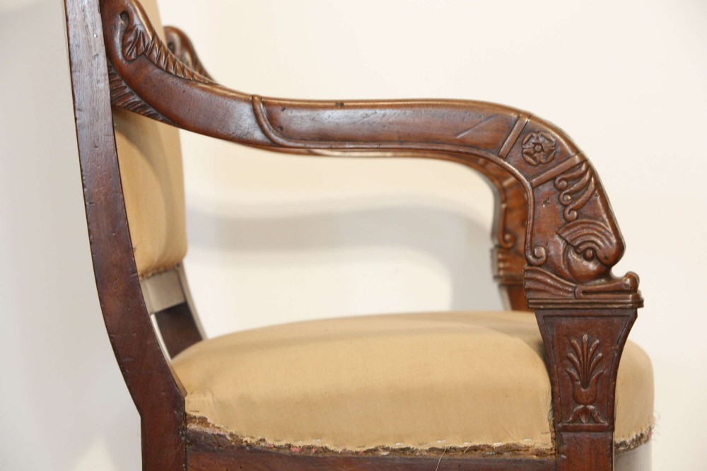 An early nineteenth-century French Empire carved mahogany armchair with padded seat and backrest, curved arms, and carved front legs. View XIII