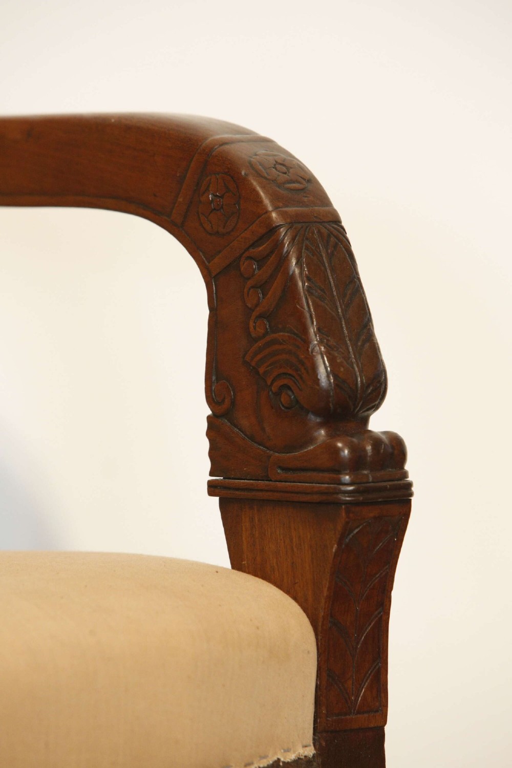 An early nineteenth-century French Empire carved mahogany armchair with padded seat and backrest, curved arms, and carved front legs. View XIV