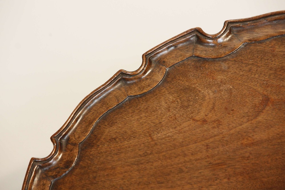 A George III mahogany oval tray featuring a hand-carved pie crust scalloped rim and rich wood grain. View VI
