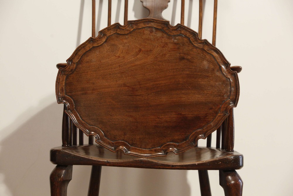 A George III mahogany oval tray featuring a hand-carved pie crust scalloped rim and rich wood grain. View X