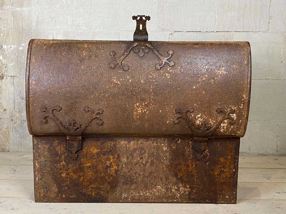 An 18th-century wrought iron trunk featuring a domed lid, decorative latch detail, side drop handles, and an oxidised rust brown surface. View II