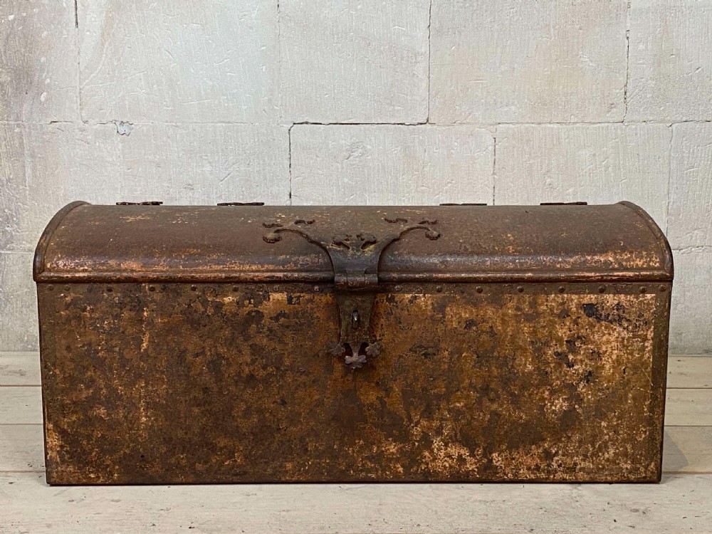 An 18th-century wrought iron trunk featuring a domed lid, decorative latch detail, side drop handles, and an oxidised rust brown surface. View III