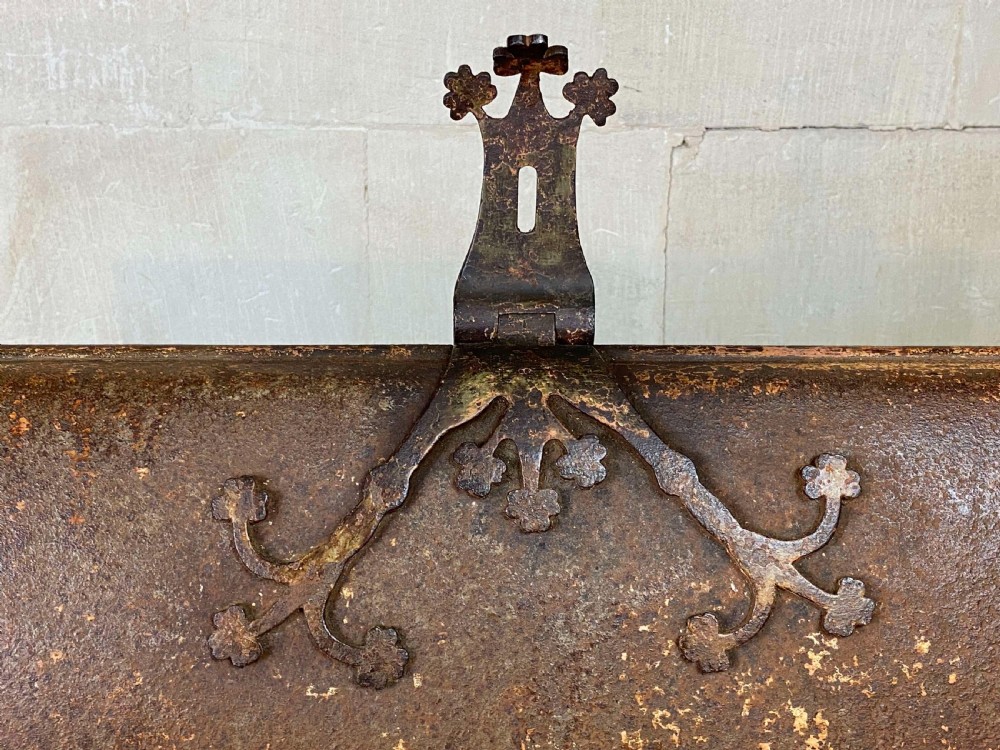 An 18th-century wrought iron trunk featuring a domed lid, decorative latch detail, side drop handles, and an oxidised rust brown surface. View XI