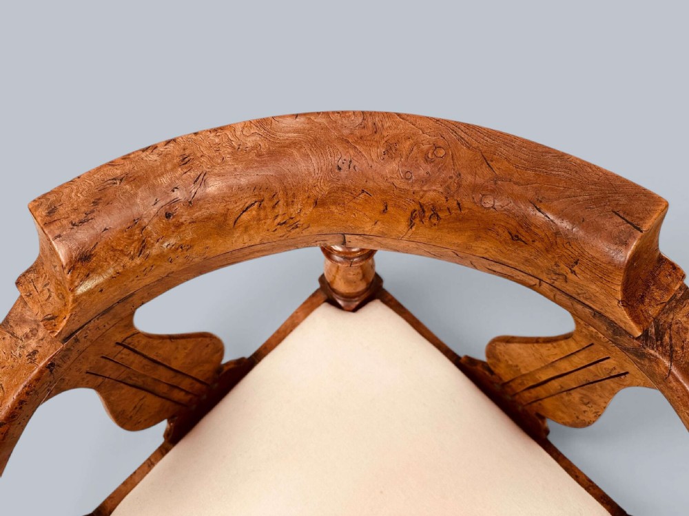 A Victorian corner chair crafted from burr elm featuring turned upright supports, shaped back splats, a curved top rail, and a cream upholstered drop-in seat. View XIII