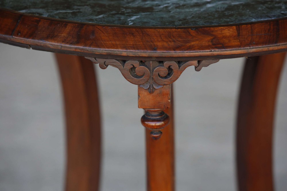 A circular 19th-century French gueridon table featuring a dark green marble top supported by three curved mahogany legs resting on a shaped triform base. View IV