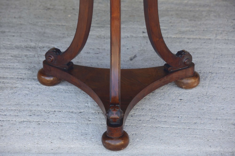 A circular 19th-century French gueridon table featuring a dark green marble top supported by three curved mahogany legs resting on a shaped triform base. View VI
