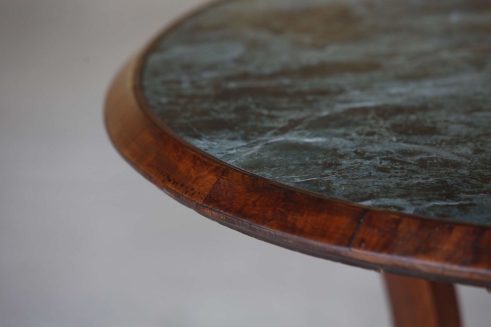 A circular 19th-century French gueridon table featuring a dark green marble top supported by three curved mahogany legs resting on a shaped triform base. View VII