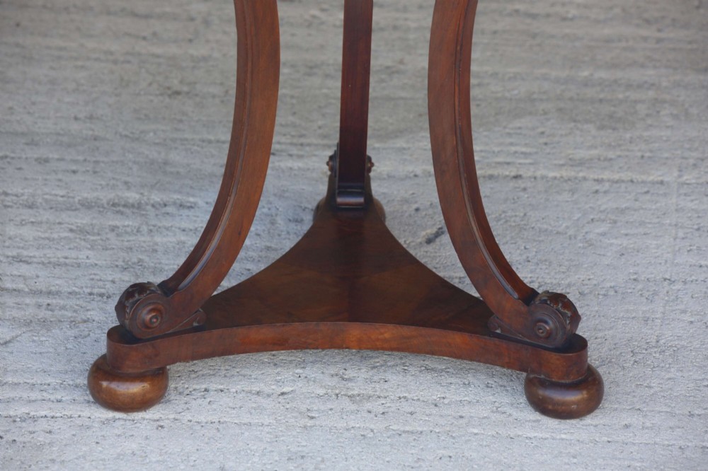 A circular 19th-century French gueridon table featuring a dark green marble top supported by three curved mahogany legs resting on a shaped triform base. View IX