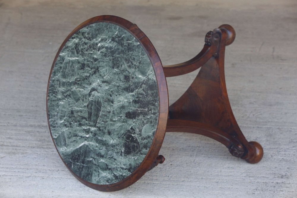 A circular 19th-century French gueridon table featuring a dark green marble top supported by three curved mahogany legs resting on a shaped triform base. View XIV