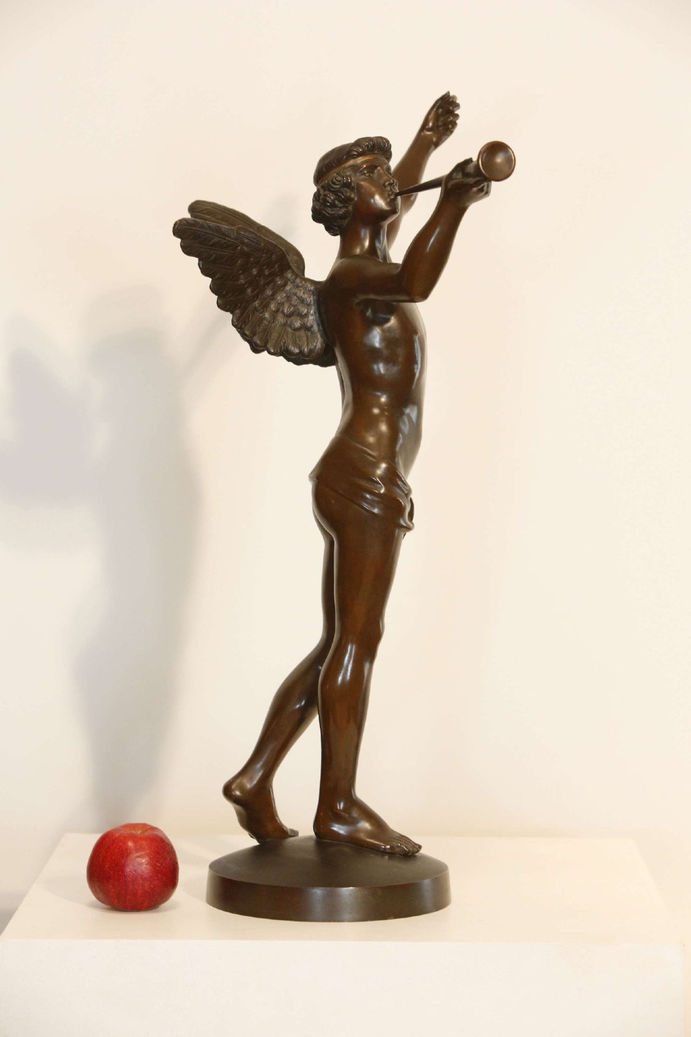 A 19th-century dark brown patinated bronze sculpture depicting the winged Archangel Gabriel blowing a trumpet raised on a round base. View V