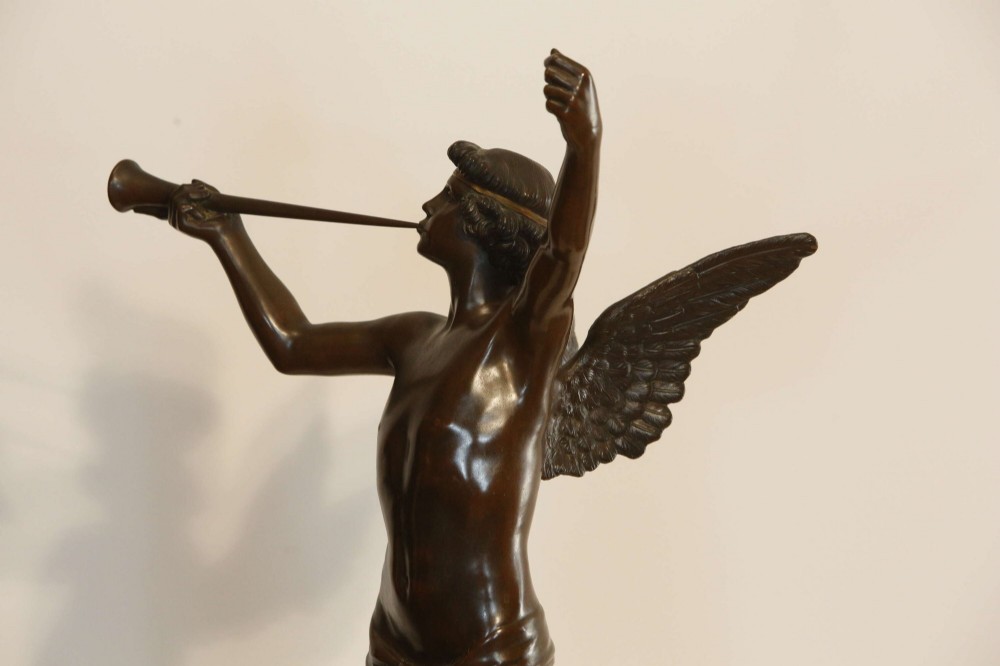 A 19th-century dark brown patinated bronze sculpture depicting the winged Archangel Gabriel blowing a trumpet raised on a round base. View VIII
