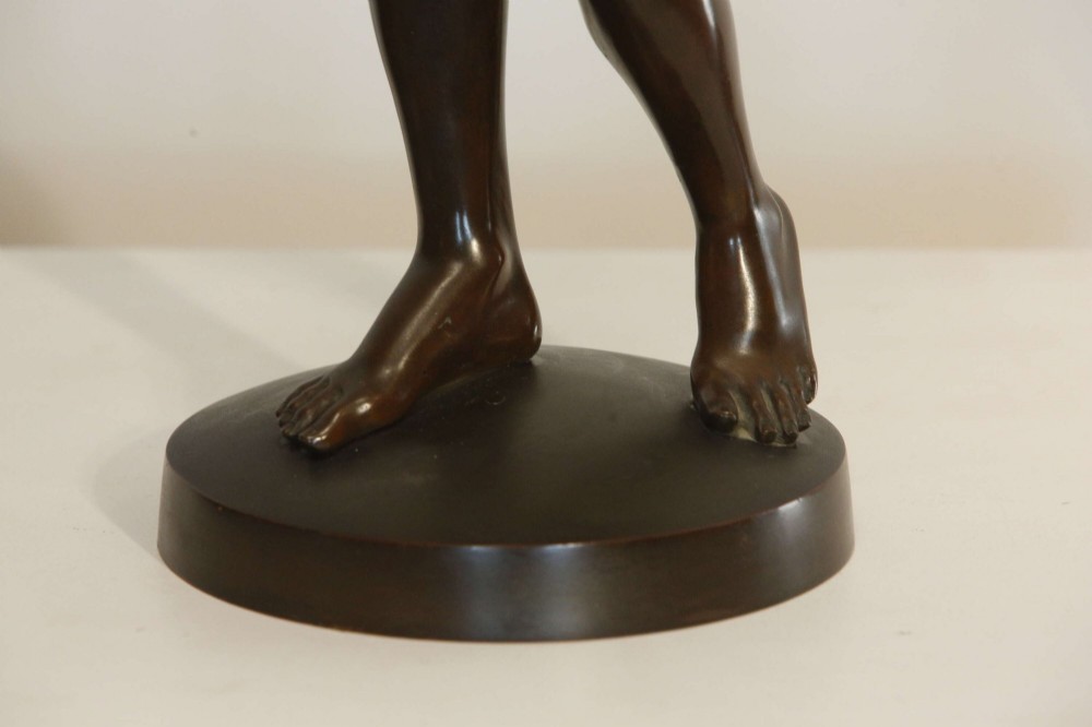 A 19th-century dark brown patinated bronze sculpture depicting the winged Archangel Gabriel blowing a trumpet raised on a round base. View IX