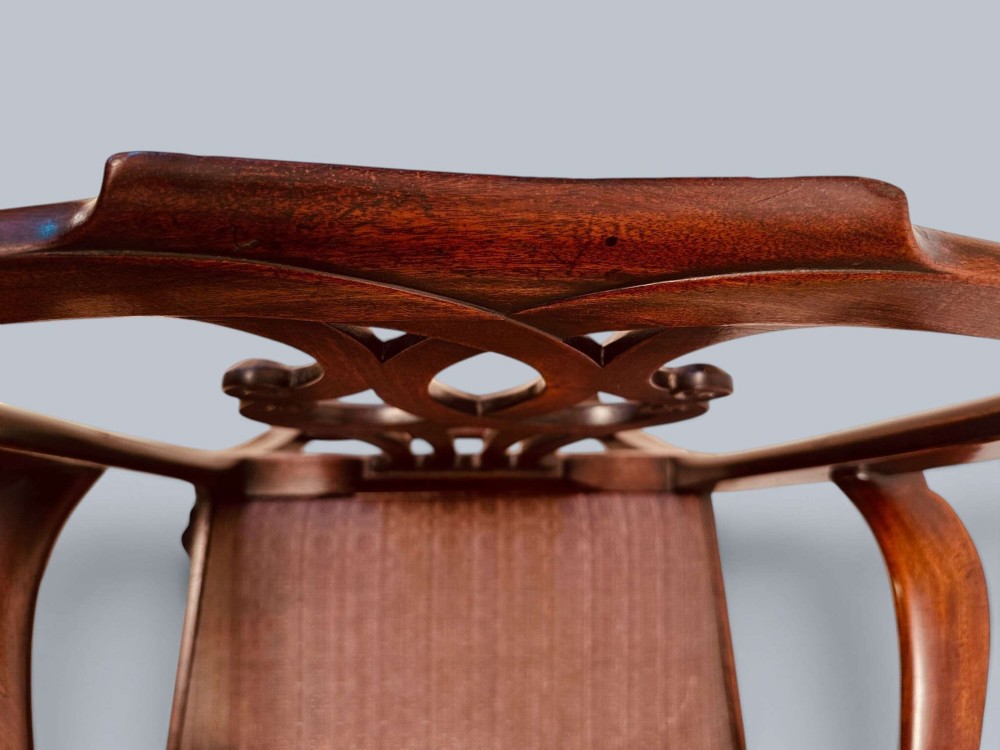 A pair of 19th-century mahogany Chippendale style armchairs featuring carved pierced splat backs, curving armrests, and patterned fabric seats. View XIV