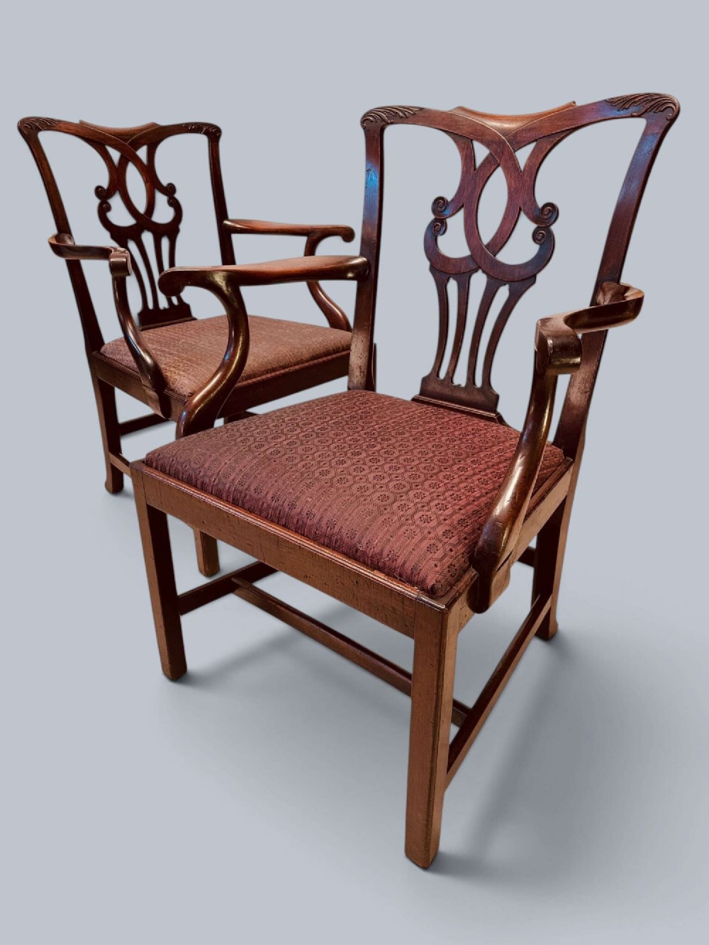 A pair of 19th-century mahogany Chippendale style armchairs featuring carved pierced splat backs, curving armrests, and patterned fabric seats. View XV