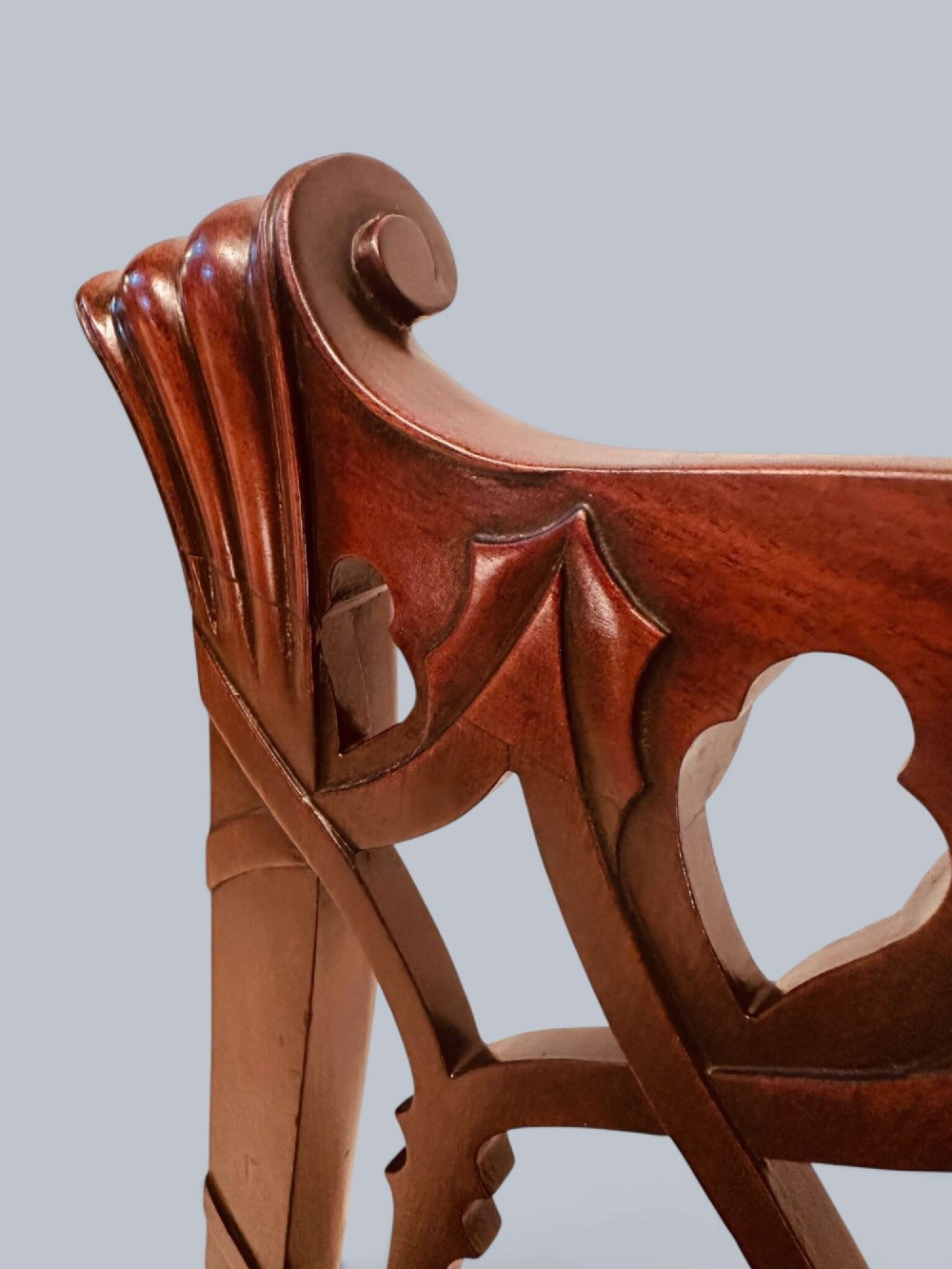 A pair of mahogany side chairs featuring pierced Gothic tracery backrests, straight square legs with H-stretchers, and patterned red fabric upholstery. View XII