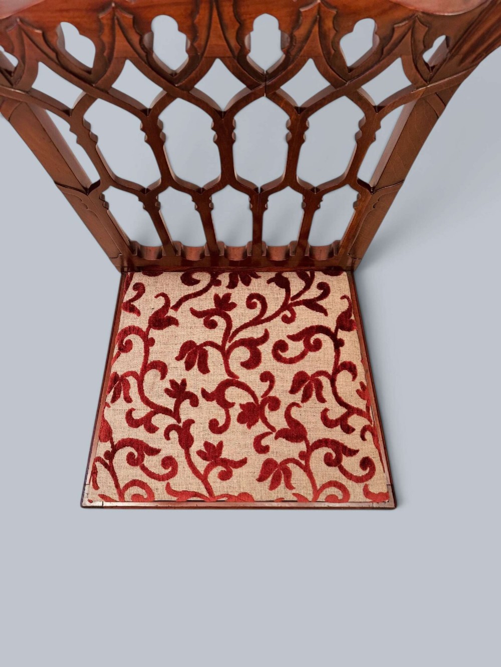 A pair of mahogany side chairs featuring pierced Gothic tracery backrests, straight square legs with H-stretchers, and patterned red fabric upholstery. View XV