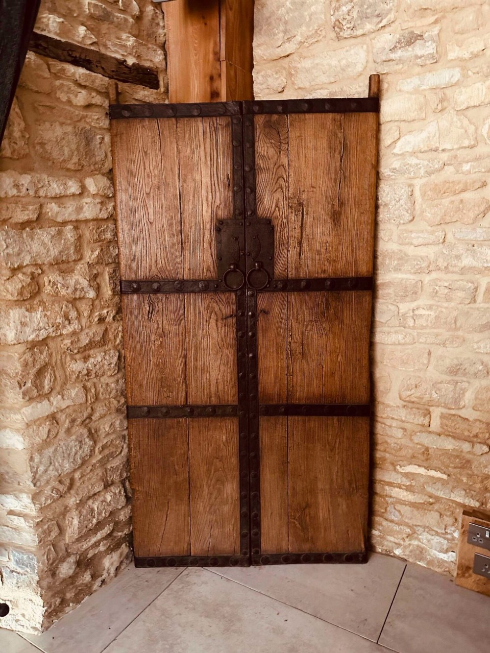 Pair of late nineteenth-century reclaimed Chinese elm doors featuring heavy iron strapping, metal studs, and central ring handles.