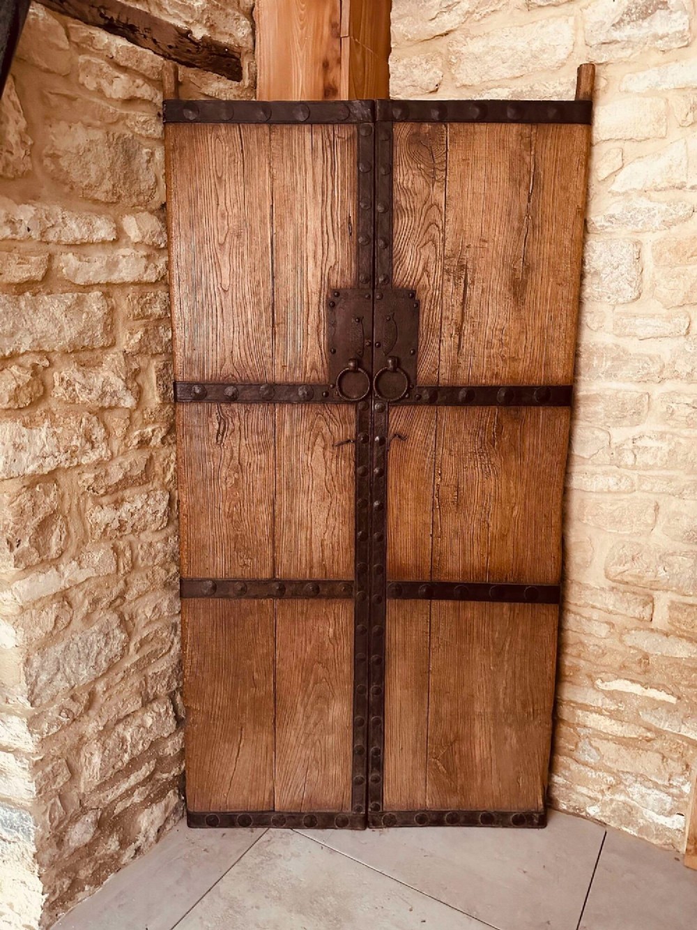 Pair of late nineteenth-century reclaimed Chinese elm doors featuring heavy iron strapping, metal studs, and central ring handles. View III