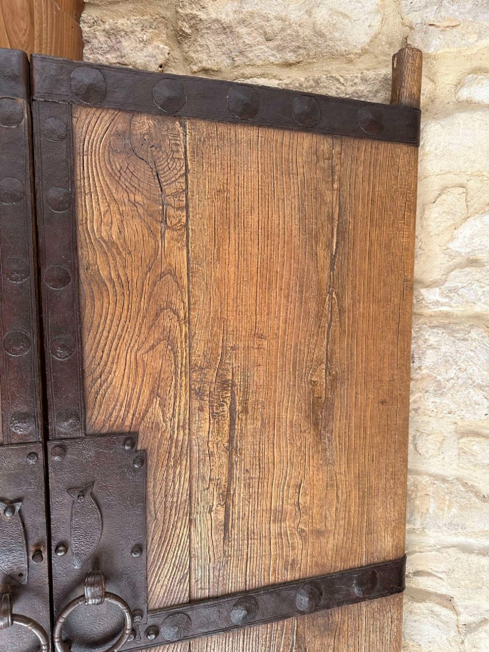 Pair of late nineteenth-century reclaimed Chinese elm doors featuring heavy iron strapping, metal studs, and central ring handles. View V