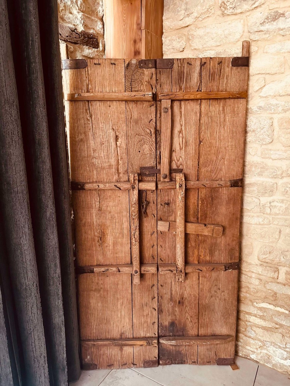 Pair of late nineteenth-century reclaimed Chinese elm doors featuring heavy iron strapping, metal studs, and central ring handles. View VIII