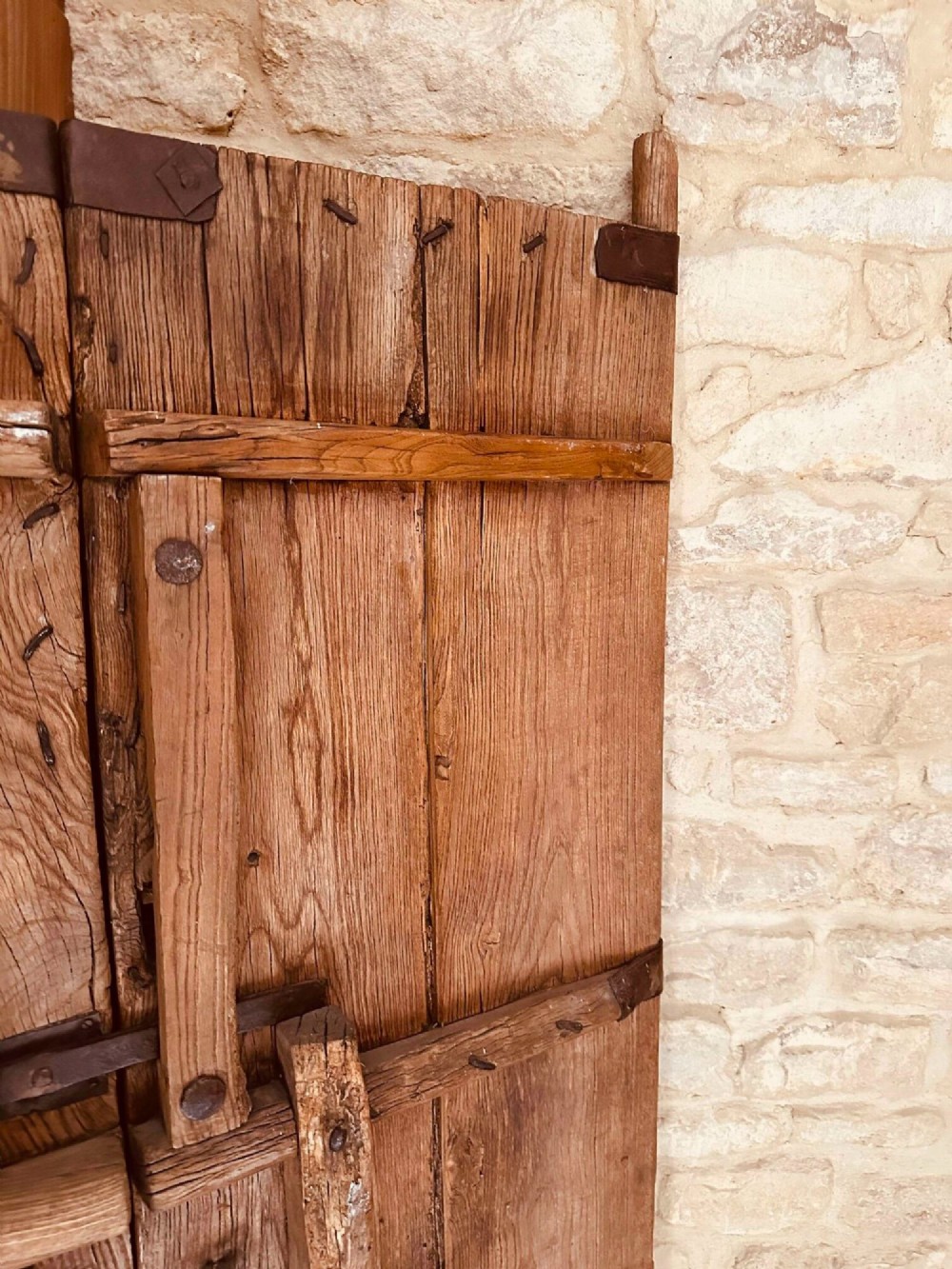 Pair of late nineteenth-century reclaimed Chinese elm doors featuring heavy iron strapping, metal studs, and central ring handles. View X