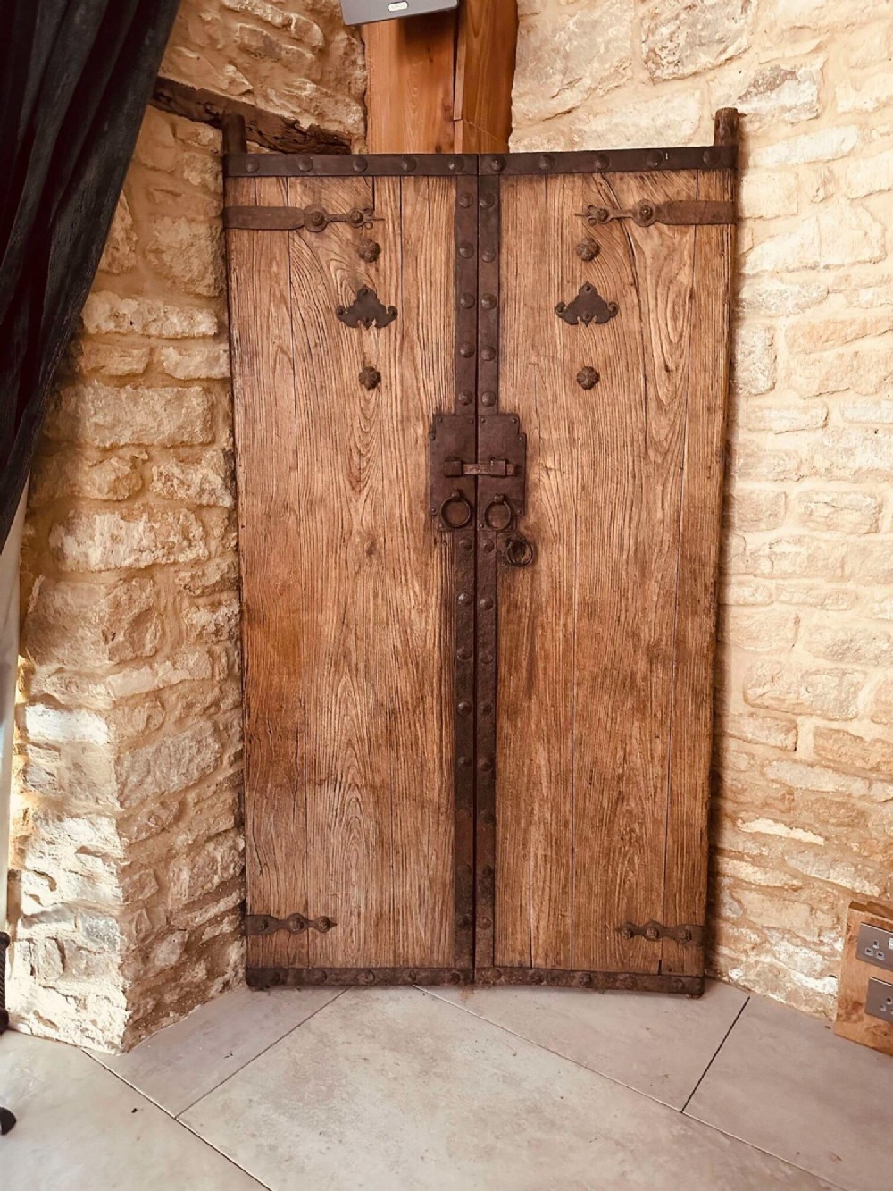 A pair of antique Chinese reclaimed locust wood doors with iron straps, decorative studs, and central ring handles.