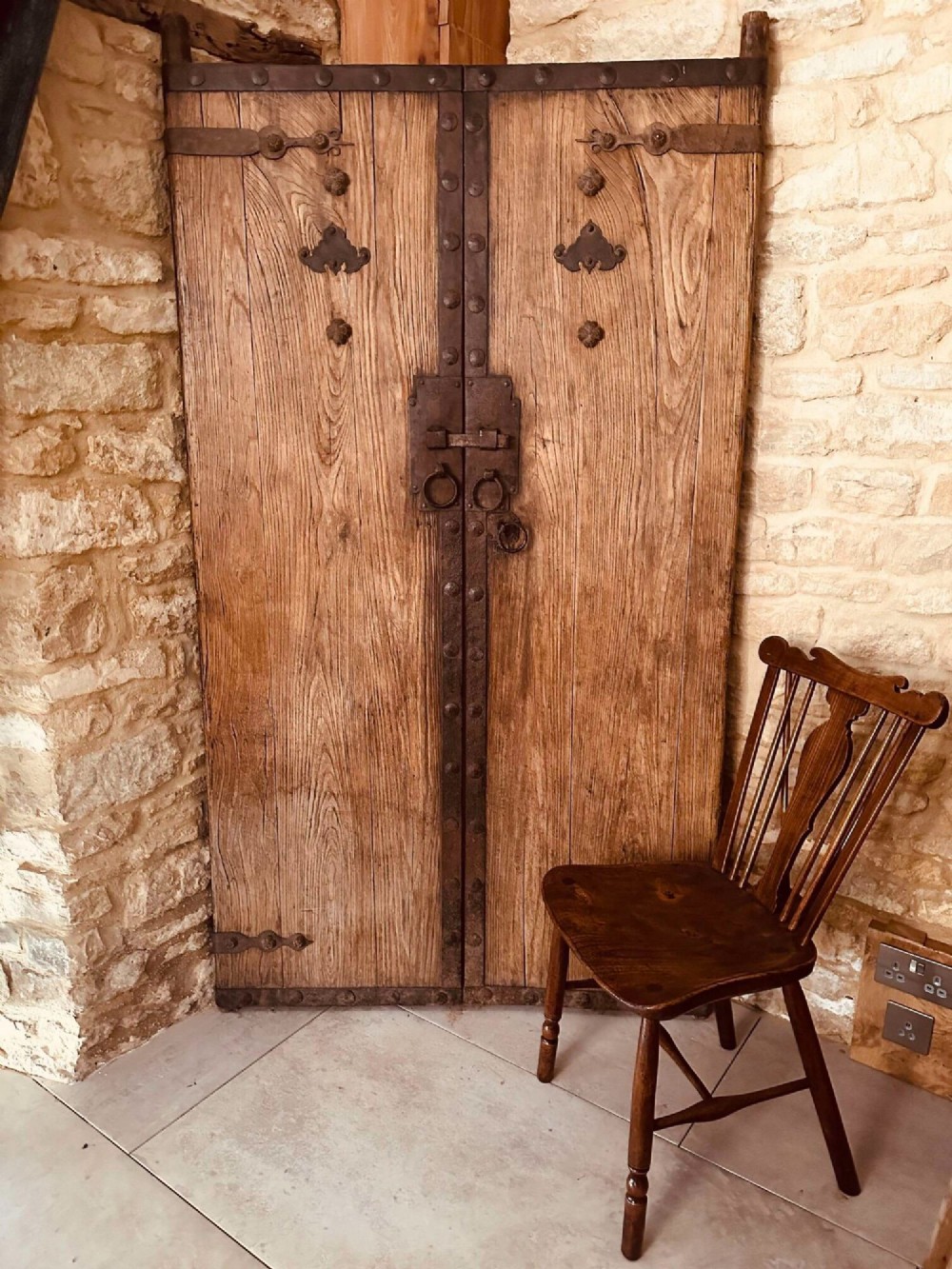 A pair of antique Chinese reclaimed locust wood doors with iron straps, decorative studs, and central ring handles. View II