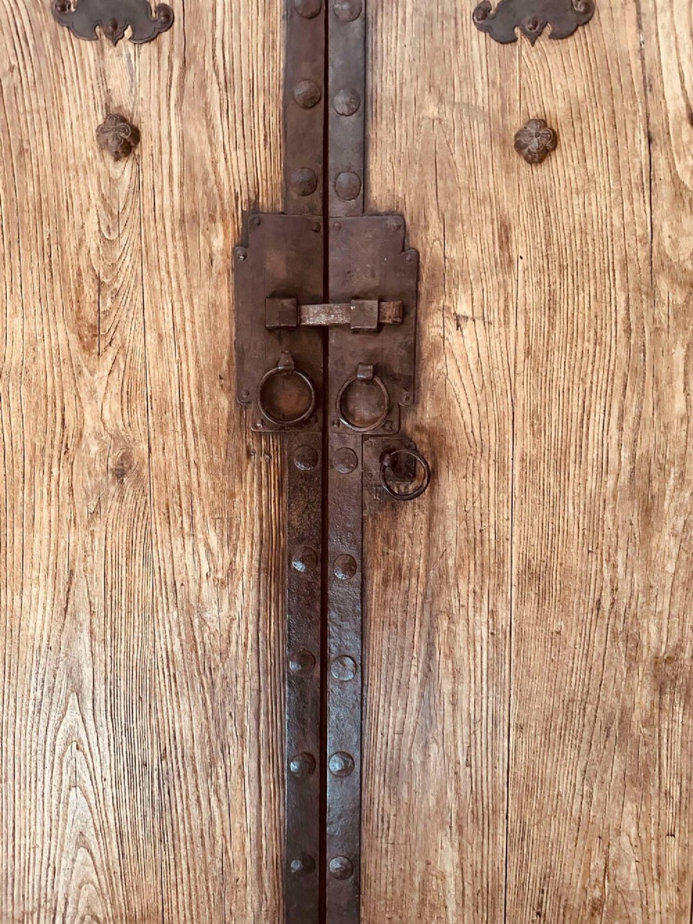 A pair of antique Chinese reclaimed locust wood doors with iron straps, decorative studs, and central ring handles. View III