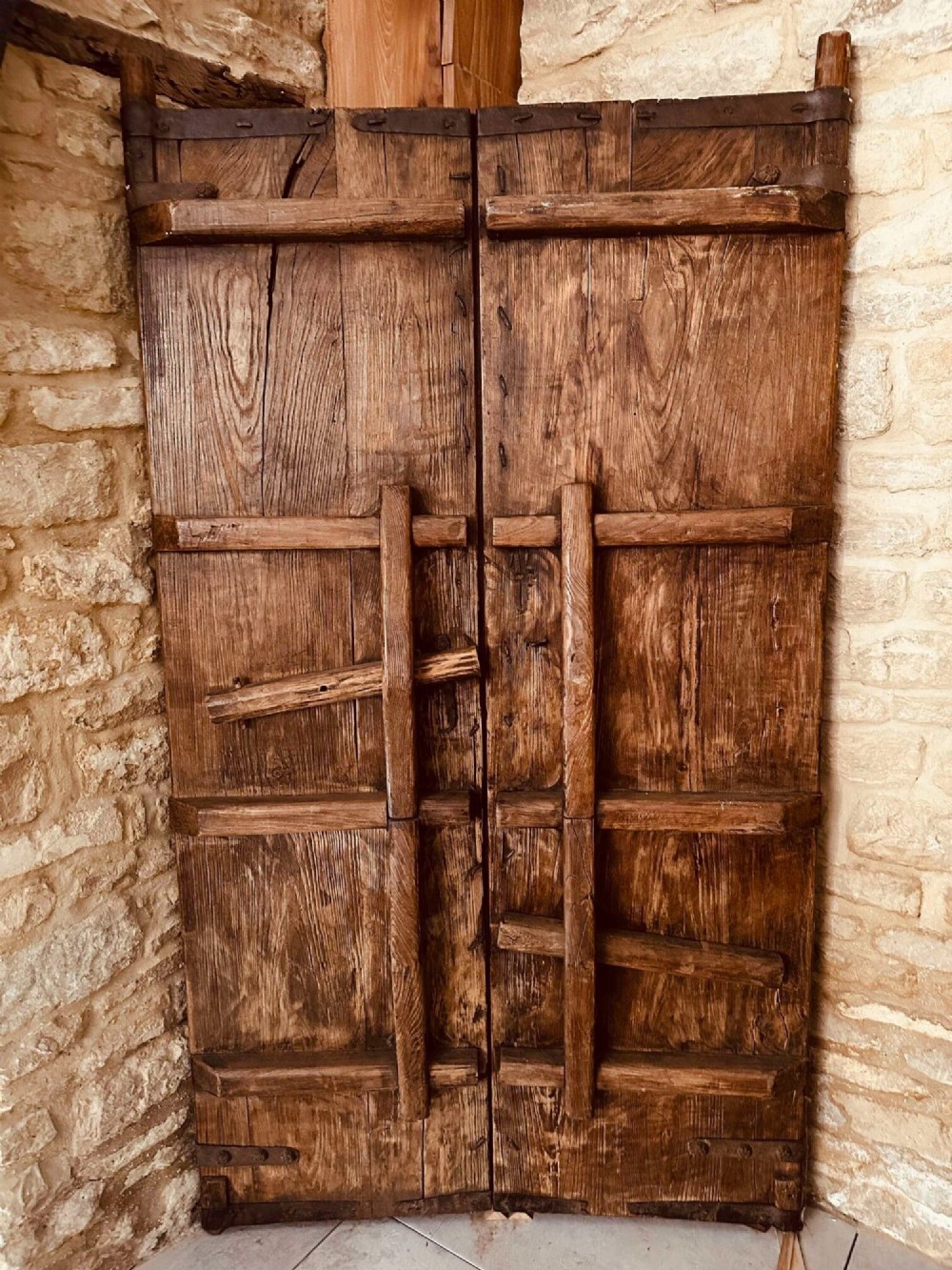 A pair of antique Chinese reclaimed locust wood doors with iron straps, decorative studs, and central ring handles. View IX