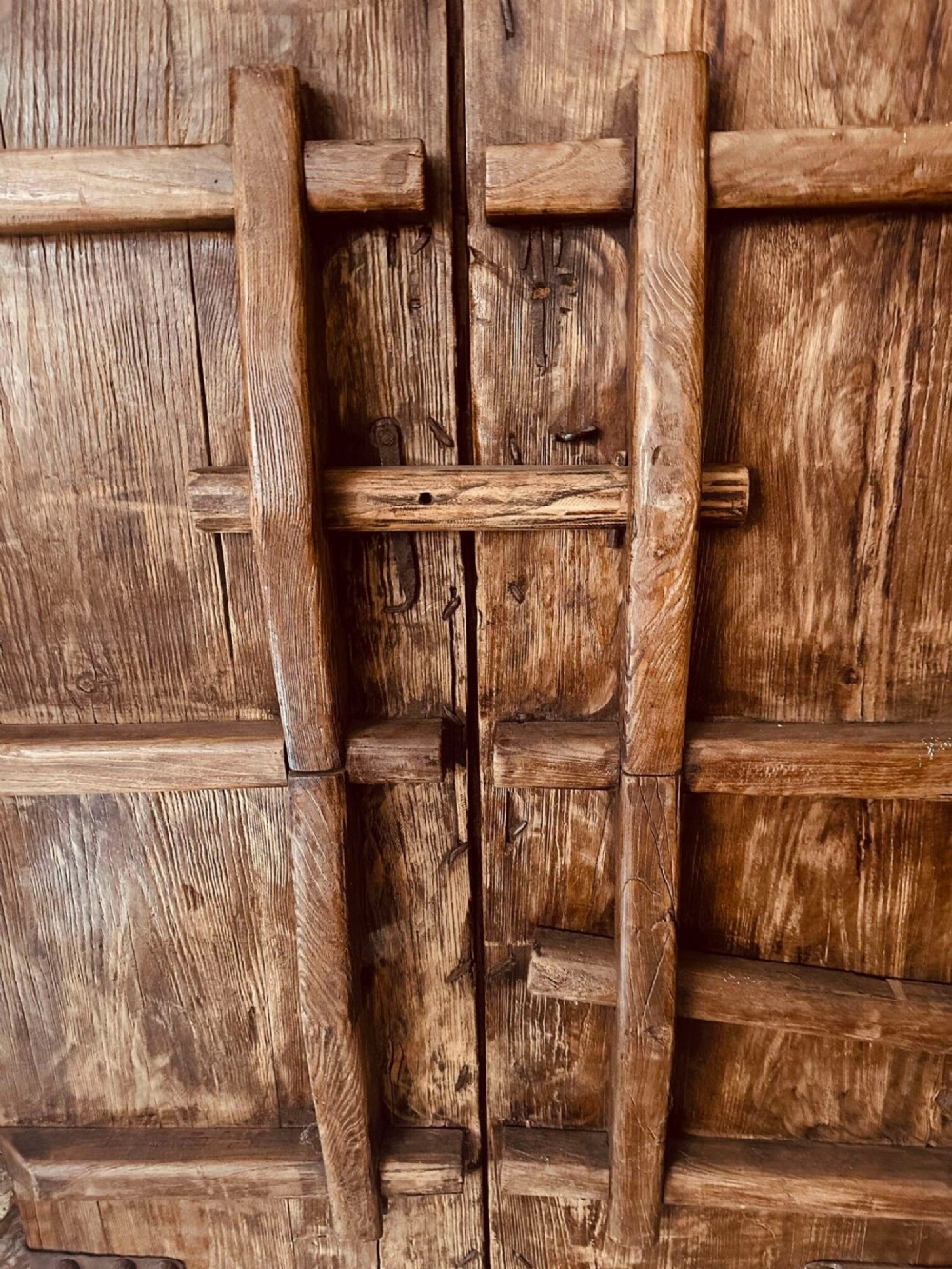 A pair of antique Chinese reclaimed locust wood doors with iron straps, decorative studs, and central ring handles. View X