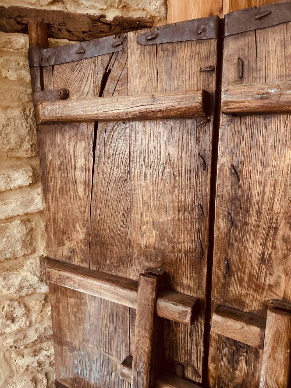 A pair of antique Chinese reclaimed locust wood doors with iron straps, decorative studs, and central ring handles. View XII