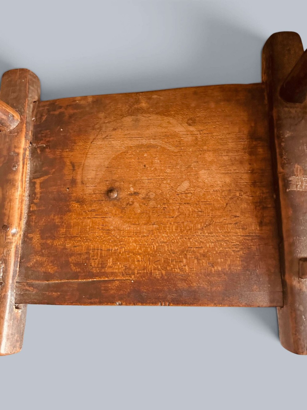 A small hand-carved rustic wooden child chair with a curved branch backrest and chunky square-cut legs. View IX