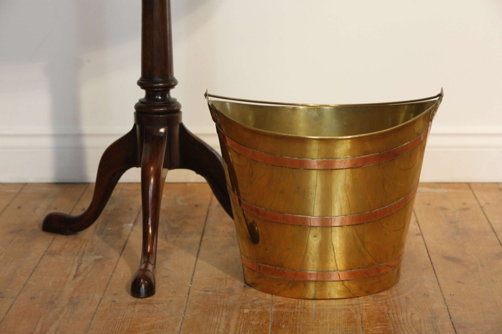 A Georgian brass peat bucket featuring flared sides, three horizontal copper bands, and a curved upper rim. View II