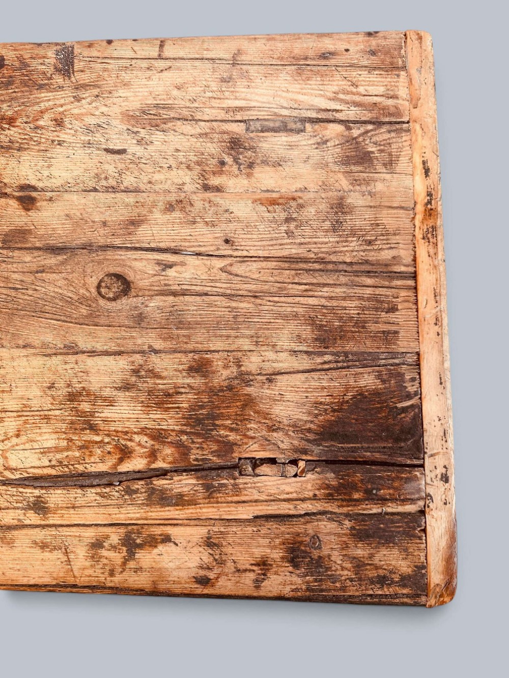 A low rustic pine market table featuring thick block legs, exposed mortise and tenon joinery, and a weathered wood top. View VI
