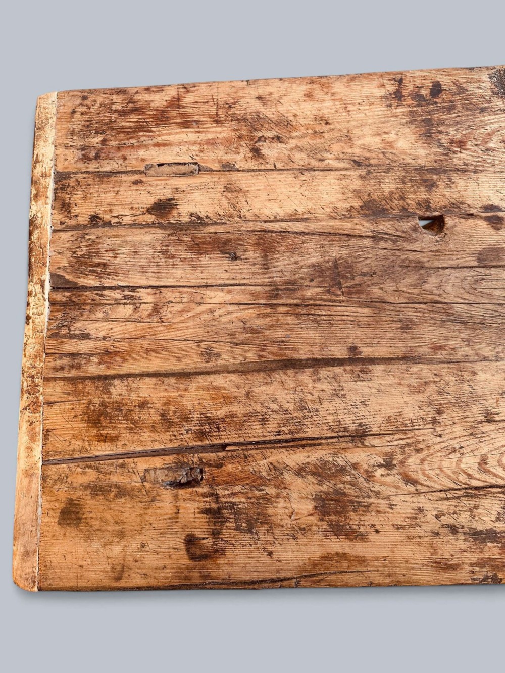 A low rustic pine market table featuring thick block legs, exposed mortise and tenon joinery, and a weathered wood top. View VII